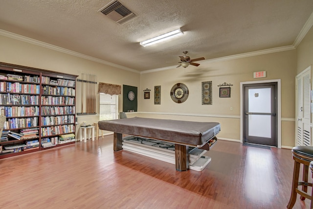 game room with billiards, a textured ceiling, crown molding, and dark wood-type flooring