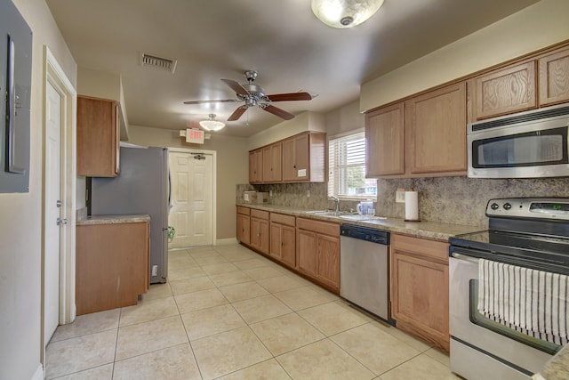 kitchen featuring ceiling fan, sink, appliances with stainless steel finishes, light tile flooring, and tasteful backsplash