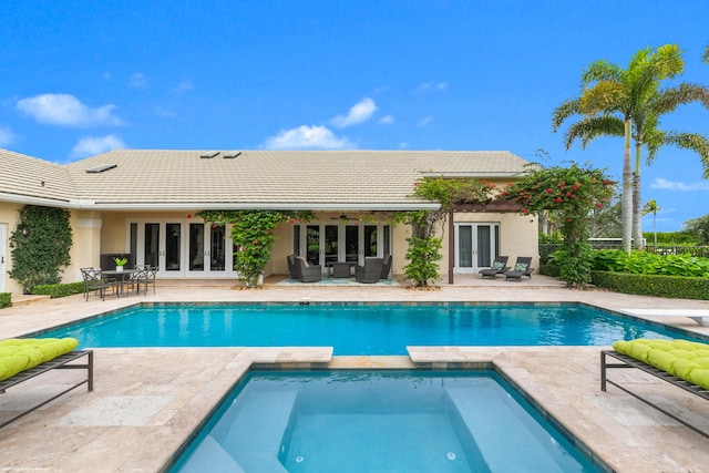 view of swimming pool with an in ground hot tub, french doors, and a patio