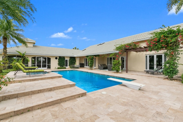 view of swimming pool featuring a patio area and a diving board