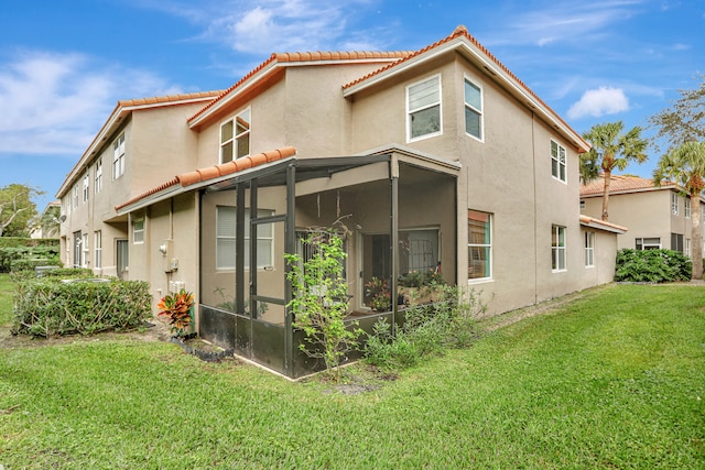 back of property featuring a sunroom and a yard