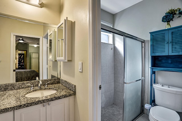 bathroom featuring walk in shower, vanity, toilet, and ceiling fan