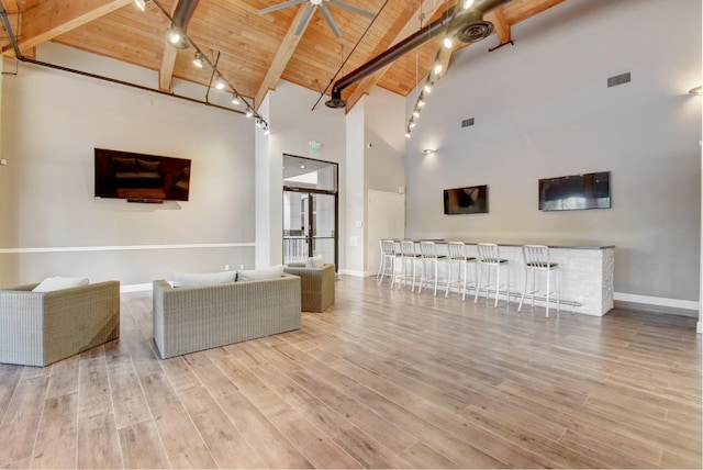 unfurnished living room featuring high vaulted ceiling, beamed ceiling, indoor bar, and wooden ceiling