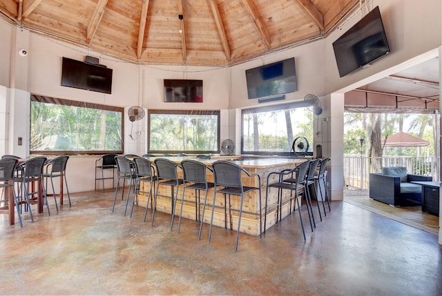 kitchen featuring wooden ceiling, concrete flooring, beamed ceiling, and high vaulted ceiling