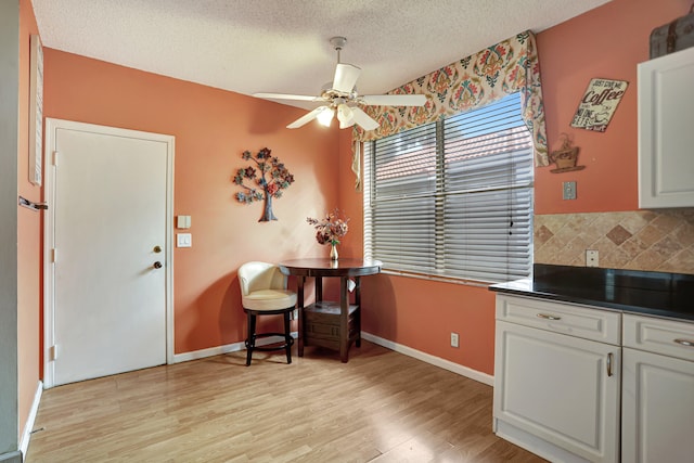 sitting room with light wood-type flooring, a textured ceiling, and ceiling fan