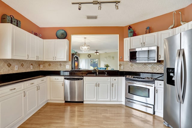 kitchen featuring light hardwood / wood-style floors, sink, appliances with stainless steel finishes, a textured ceiling, and white cabinets