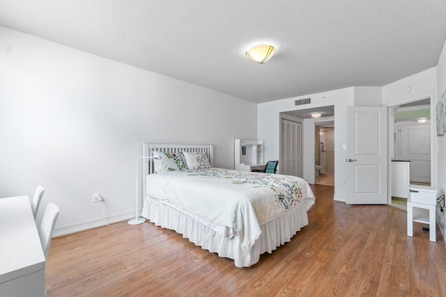 bedroom featuring a textured ceiling and hardwood / wood-style flooring