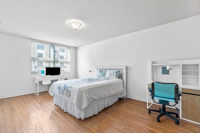 bedroom featuring a textured ceiling and hardwood / wood-style flooring