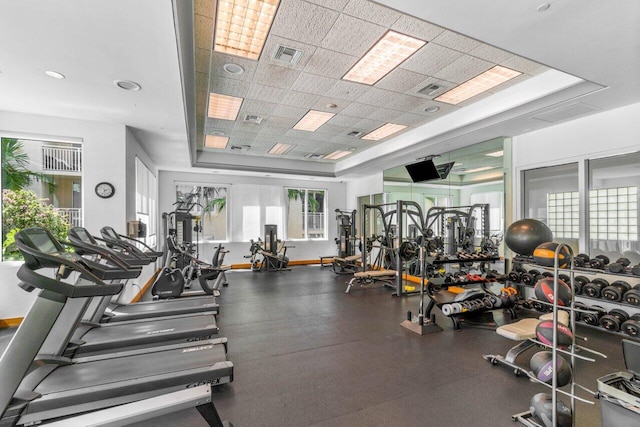 gym featuring a raised ceiling