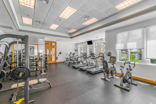 exercise room featuring a paneled ceiling and a tray ceiling