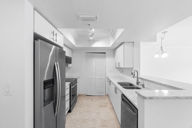 kitchen featuring a tray ceiling, white cabinetry, decorative light fixtures, and appliances with stainless steel finishes