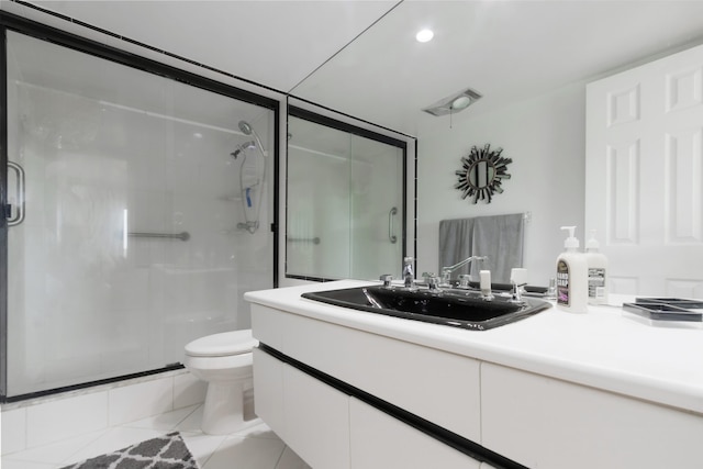 bathroom with toilet, tile flooring, a shower with shower door, and vanity