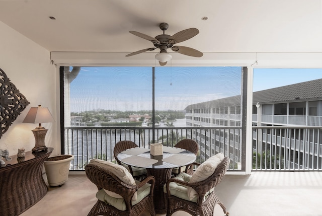 sunroom featuring a water view and ceiling fan