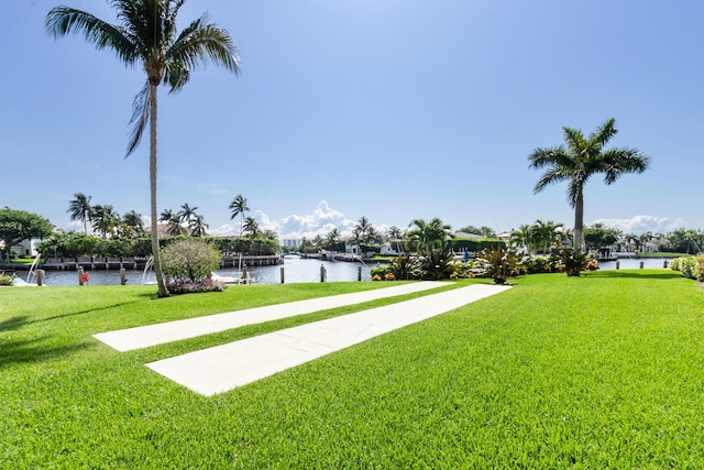 view of home's community with a water view and a lawn