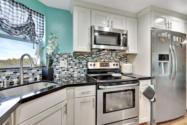 kitchen featuring sink, appliances with stainless steel finishes, light hardwood / wood-style flooring, backsplash, and white cabinetry