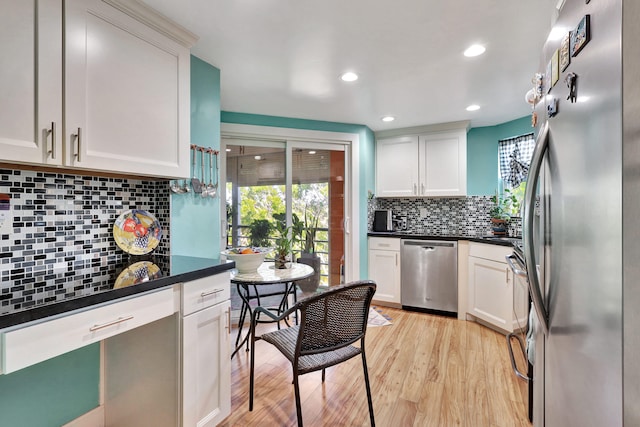 kitchen featuring backsplash, light hardwood / wood-style floors, stainless steel appliances, and white cabinetry