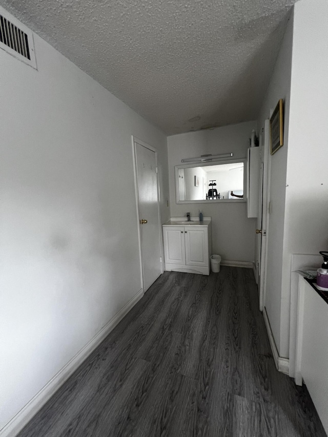 interior space with dark hardwood / wood-style floors, sink, and a textured ceiling