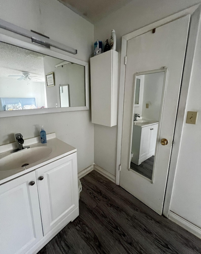 bathroom with wood-type flooring, vanity, and ceiling fan