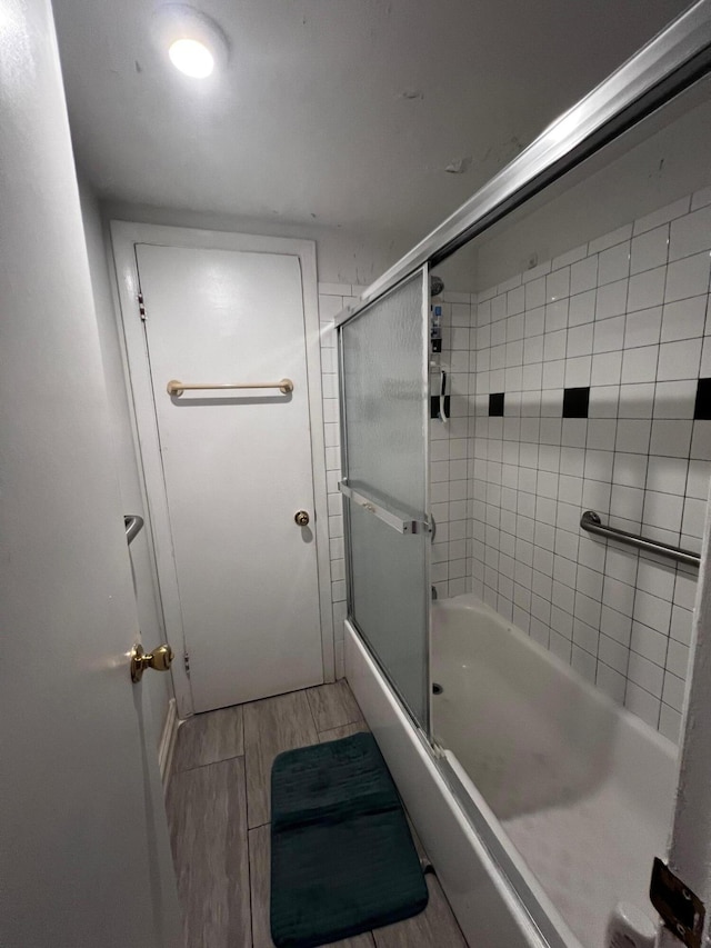 bathroom with bath / shower combo with glass door