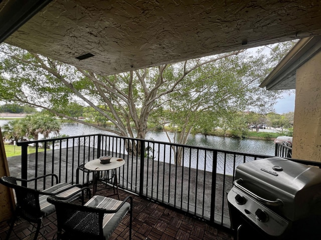 balcony with area for grilling and a water view