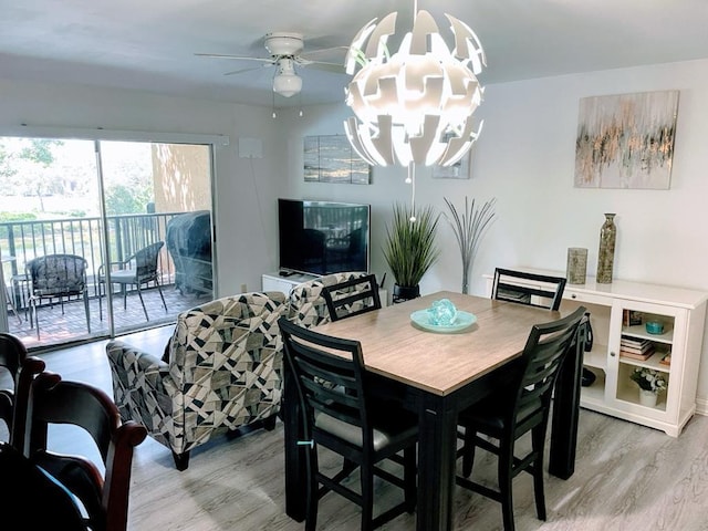 dining area featuring hardwood / wood-style floors and ceiling fan with notable chandelier