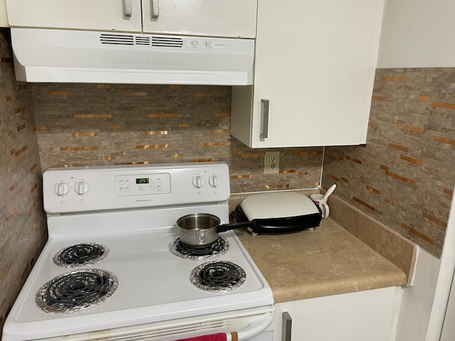 kitchen featuring decorative backsplash, ventilation hood, white range with electric stovetop, and white cabinetry