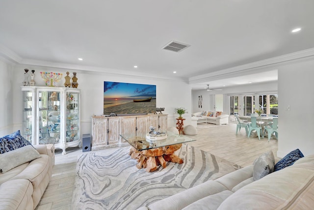 living room featuring ceiling fan, crown molding, and light hardwood / wood-style flooring