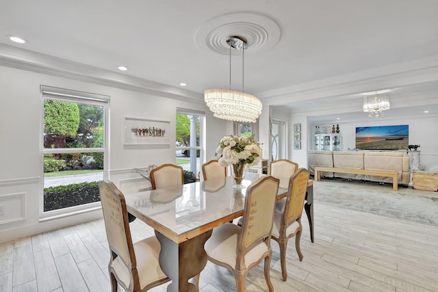 dining room featuring a notable chandelier, crown molding, and light hardwood / wood-style flooring