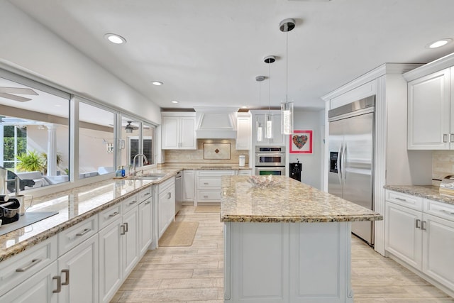 kitchen featuring sink, stainless steel appliances, tasteful backsplash, white cabinets, and custom range hood