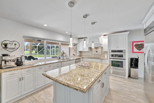 kitchen featuring appliances with stainless steel finishes, white cabinetry, hanging light fixtures, and custom exhaust hood