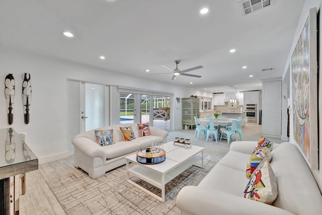 living room featuring ceiling fan, french doors, and light wood-type flooring