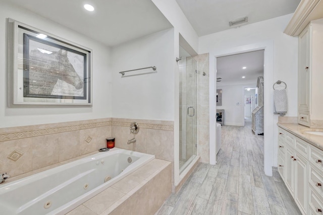 bathroom with vanity, hardwood / wood-style flooring, and separate shower and tub