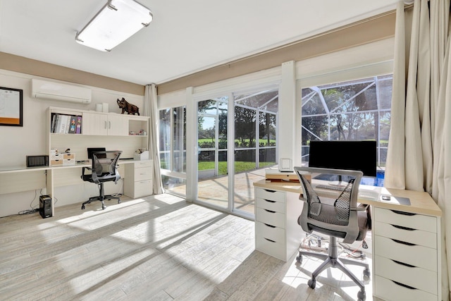 home office featuring light hardwood / wood-style flooring, plenty of natural light, and a wall mounted AC