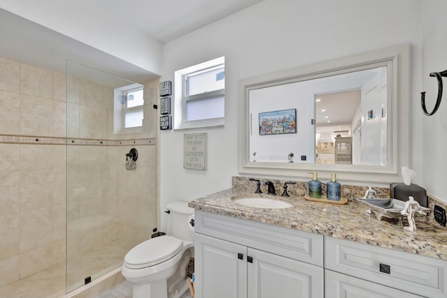 bathroom featuring tiled shower, vanity, and toilet