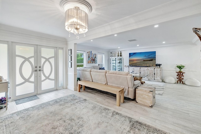 living room featuring ornamental molding, french doors, and a notable chandelier