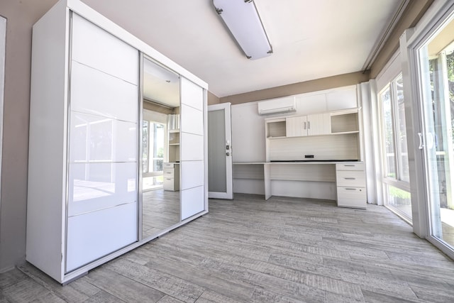 9010 S Lake Dasha Dr, Plantation, FL 33324 - kitchen featuring a wall mounted air conditioner, open shelves, light wood-style floors, and white cabinets