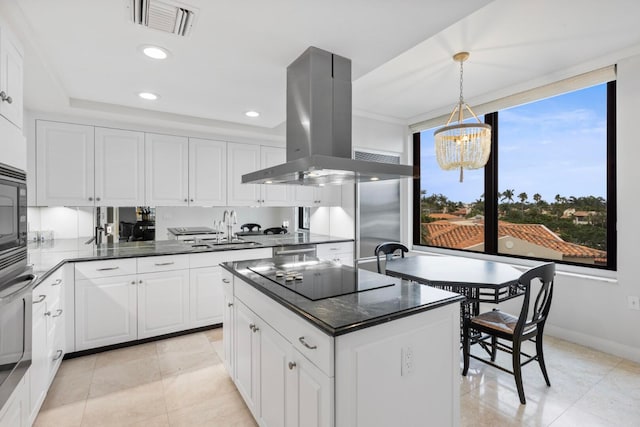 kitchen featuring visible vents, island exhaust hood, a sink, white cabinets, and appliances with stainless steel finishes