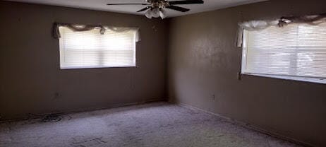 carpeted spare room featuring ceiling fan