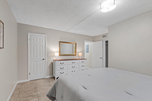 tiled bedroom featuring electric panel and a textured ceiling