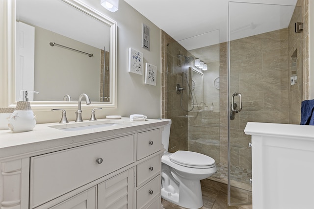 bathroom with a shower with shower door, toilet, and vanity