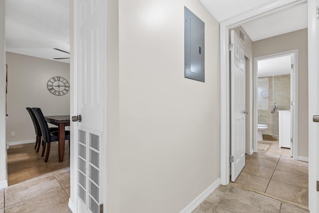 corridor with electric panel and a textured ceiling