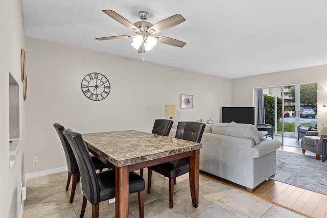 dining area with ceiling fan and a textured ceiling