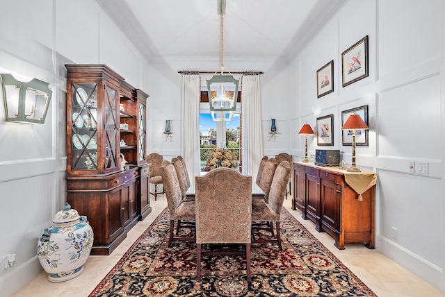 tiled dining space featuring crown molding and a chandelier