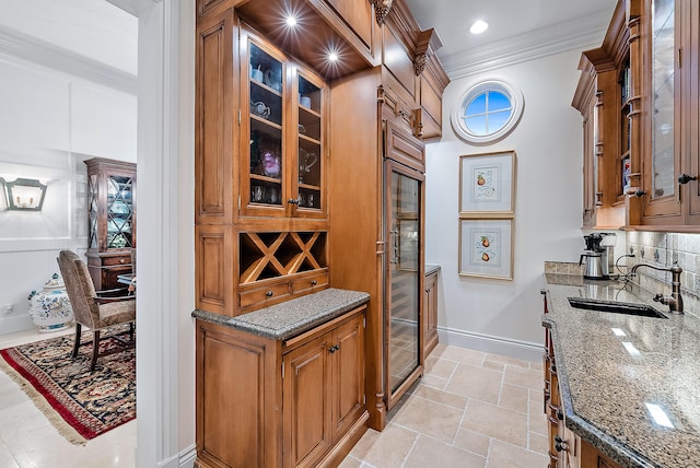 kitchen featuring sink, light tile floors, dark stone counters, crown molding, and tasteful backsplash