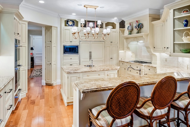 kitchen featuring backsplash, a kitchen bar, light wood-type flooring, a center island, and built in appliances