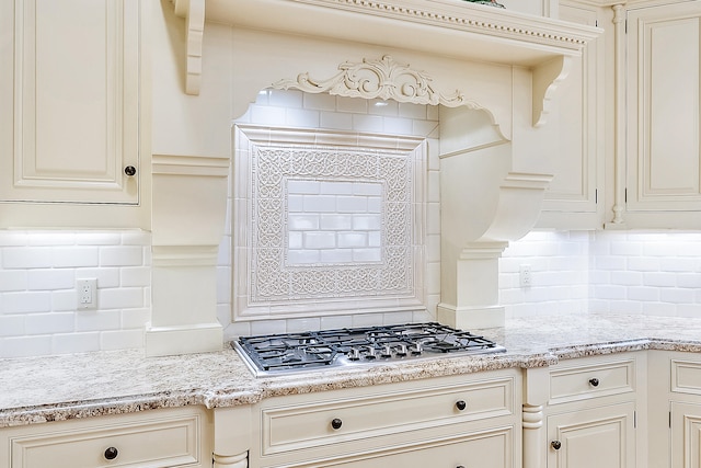 kitchen featuring light stone countertops, tasteful backsplash, and cream cabinetry