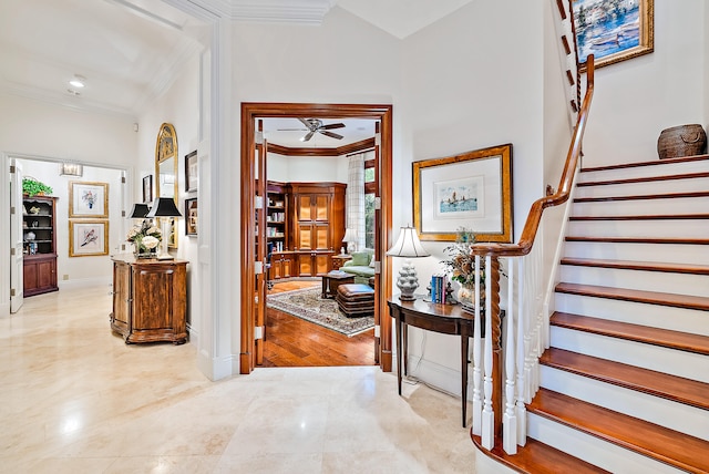 foyer entrance with crown molding, ceiling fan, and light tile floors