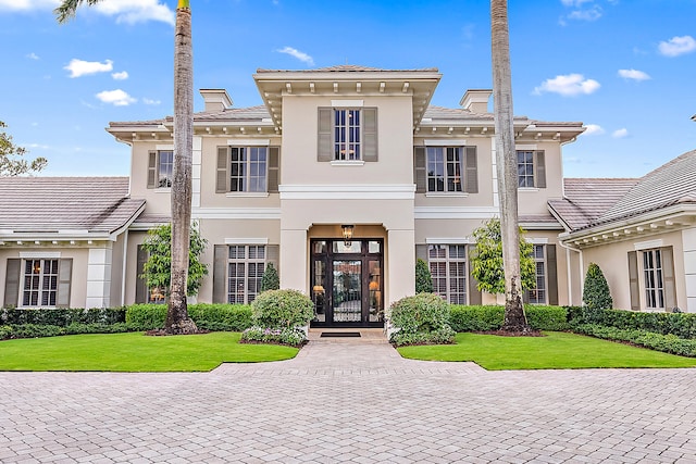 view of front of house with a front lawn and french doors