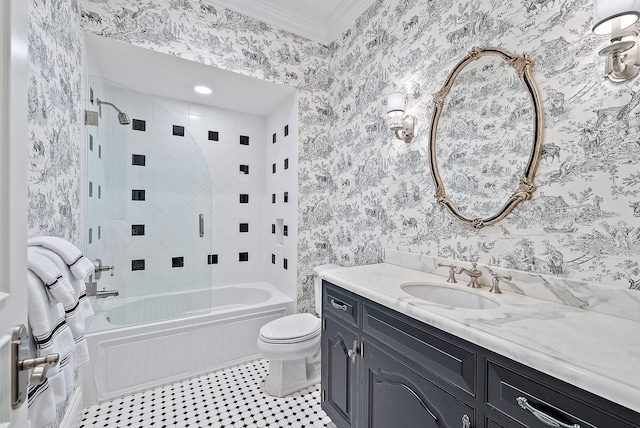 full bathroom featuring toilet, vanity with extensive cabinet space, ornamental molding, tiled shower / bath, and tile flooring