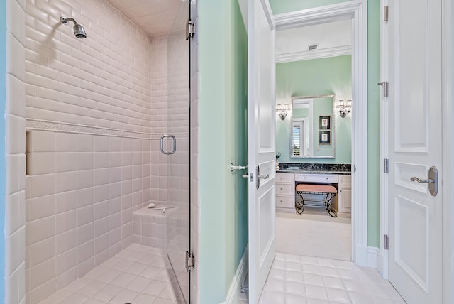 bathroom featuring a shower with shower door, vanity with extensive cabinet space, and tile flooring